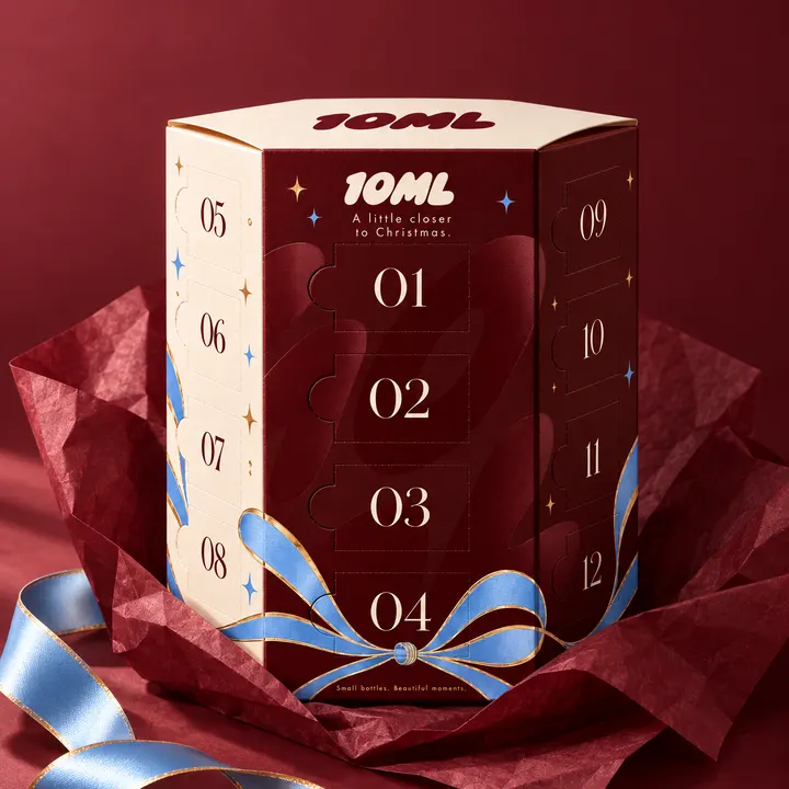 Der Kalender, ausgepackt aus rotem Seidenpapier, das Band lose daneben