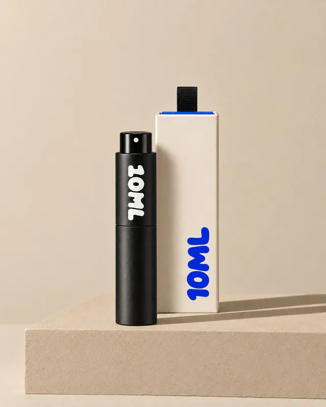 A black 10ML atomiser beside its cream box on a sand-coloured plinth