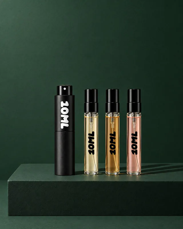 A 10ML atomiser beside three filled sample vials on a dark green plinth